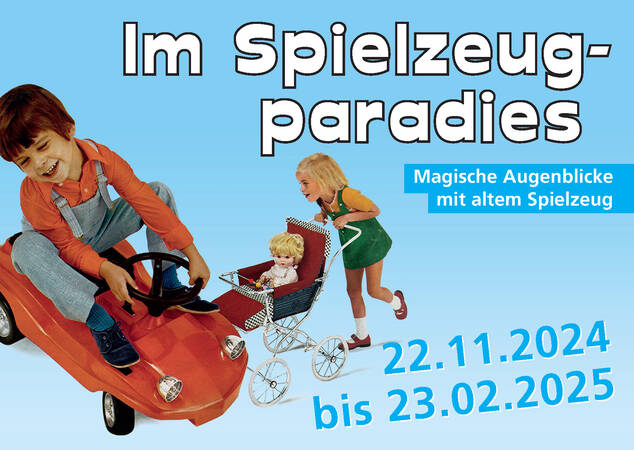 Auf einem blauen Hintergrund sind ein Junge in einem roten Spielzeugauto und ein Mädchen mit einem Puppenwagen abgebildet, begleitet von dem Text "Im Spielzeugparadies - Magische Augenblicke mit altem Spielzeug", sowie den Daten "22.11.2024 bis 23.02.2025".