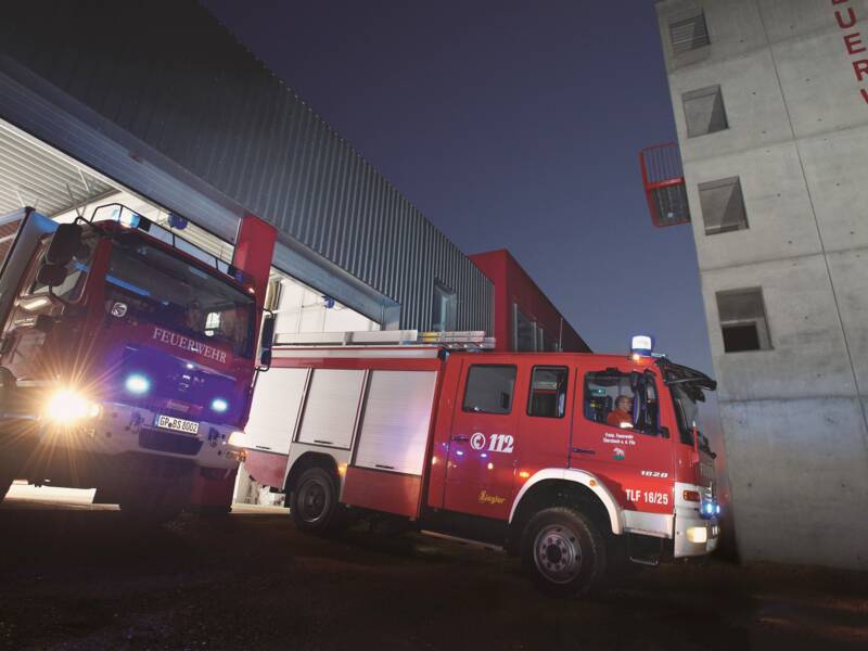 Feuerwehrfahrzeuge abends im Dunkeln vor dem Feuerwehrgerätehaus in Ebersbach an der Fils