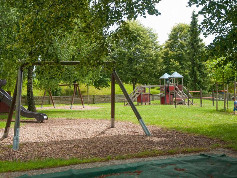 Schaukel, Rutsche und Kletterelement auf dem Spielplatz des Kindergarten Burg Steinbiss