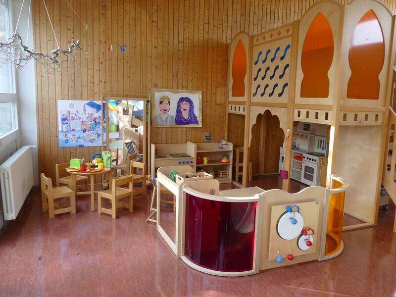 Gruppenraum mit Holztischen und Holzspielzeug im Kindergarten Pusteblume Weiler