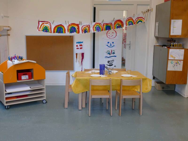 Gruppenraum im Kindergarten Ringweg in Roßwälden mit einem Rollwagen mit Bastel- und Malutensilien und einem Tisch mit fünf Stühlen