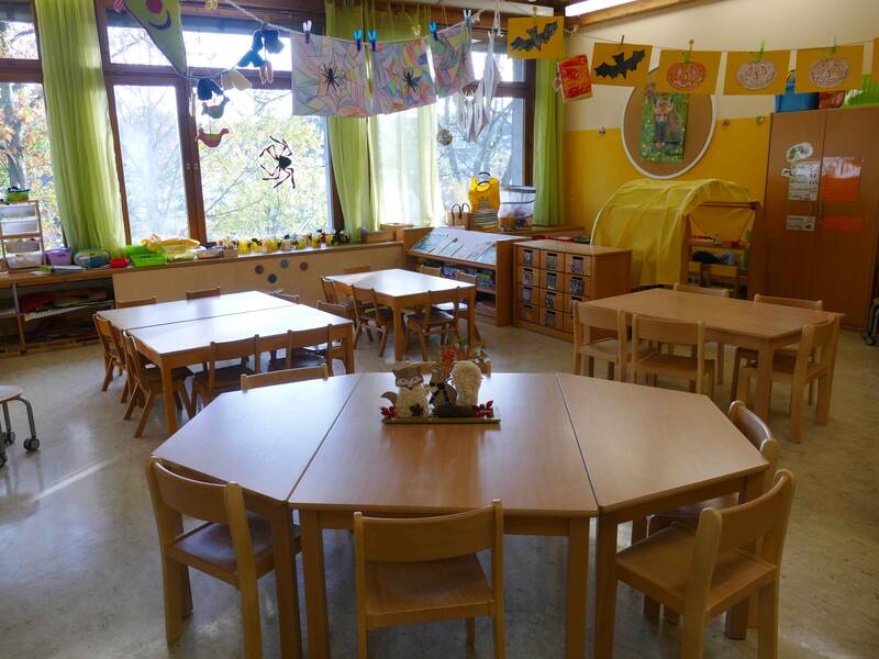 Gruppenraum im Kindergarten Sonnenschein Bünzwangen mit vier Gruppentischen aus Holz mit Kinderstühlen.