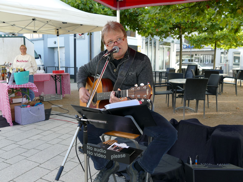 Musiker Eddy Danco spielt Gitarre und singt bei einem Auftritt auf dem Ebersbacher Wochenmarkt